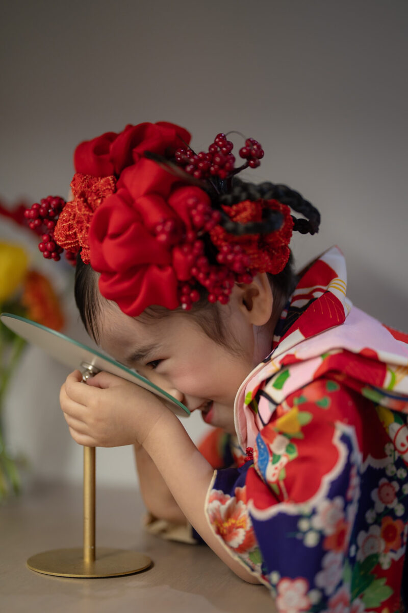 髪飾りに手を添える3歳の七五三・貸切スタジオでの自然な一瞬