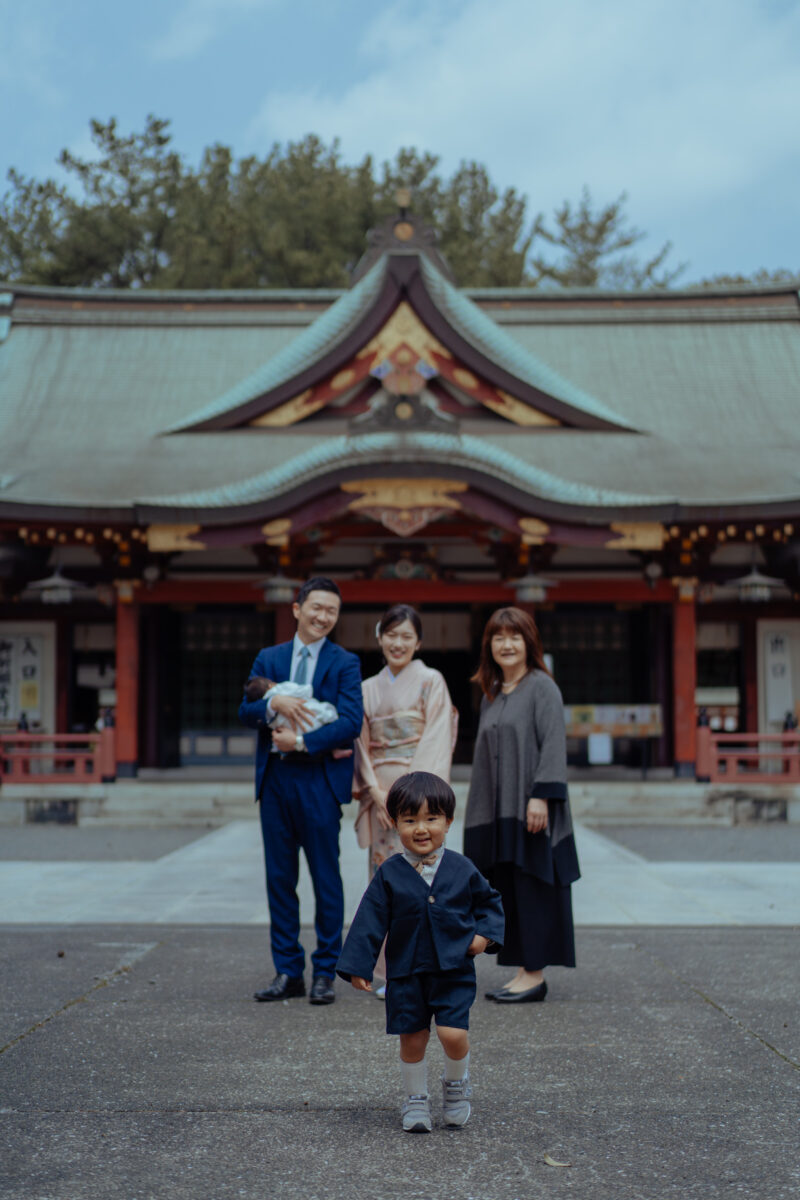 広島県福山市・福山八幡宮で撮影した出張ロケーション。3歳七五三＆お宮参りの家族写真で、袴姿の男の子が笑顔で前に立ち、ご両親・祖母・赤ちゃんを抱いたお父さんと一緒に