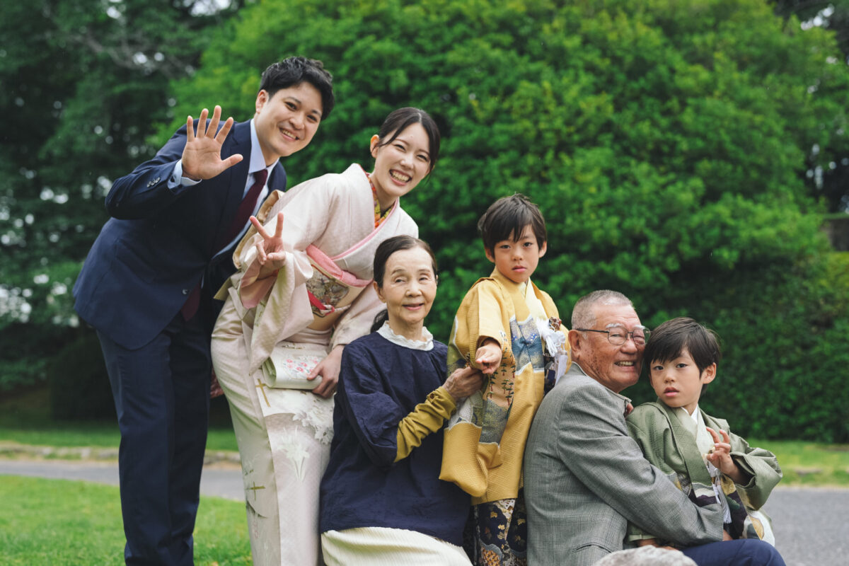 広島護国神社で撮影した3世代家族の七五三出張ロケーション。2人の男の子の七五三を祝って、ご両親・祖父母と一緒に笑顔で集合する賑やかな1枚