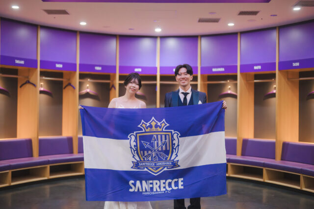 ロッカールームでサンフレッチェ広島の応援旗を広げる新郎新婦｜スタジアムフォトウェディング