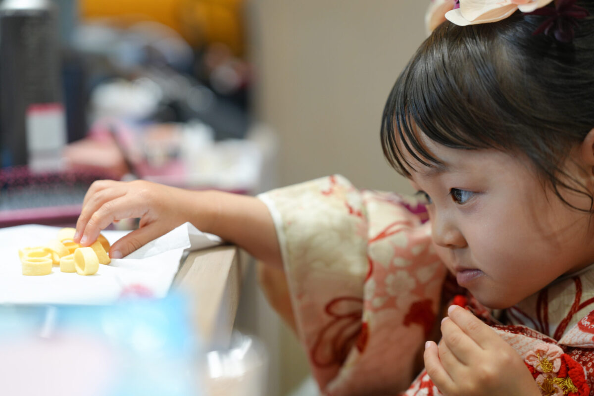 撮影の合間にお菓子で休憩する七五三の女の子｜広島市安佐南区の十色写真STUDIO