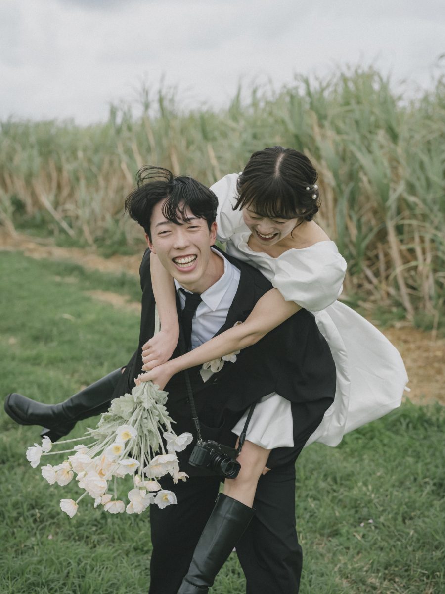 サトウキビ畑でおんぶをする新郎新婦|宮古島のフォトウェディング・十色写真STUDIO