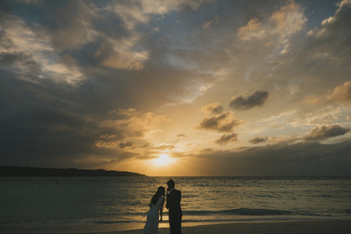 夕焼けのビーチでシルエットになる新郎新婦|宮古島のウェディングフォト・十色写真STUDIO