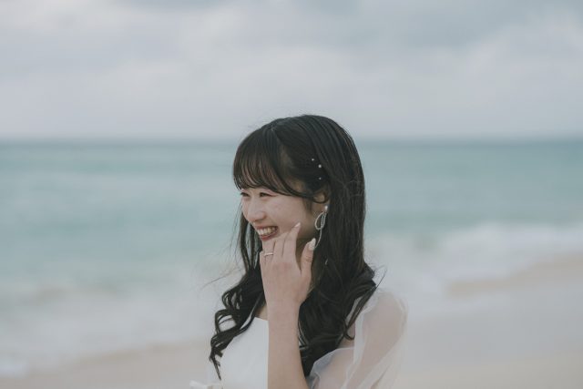 砂浜で笑う新婦のポートレート｜宮古島のフォトウェディング・十色写真STUDIO